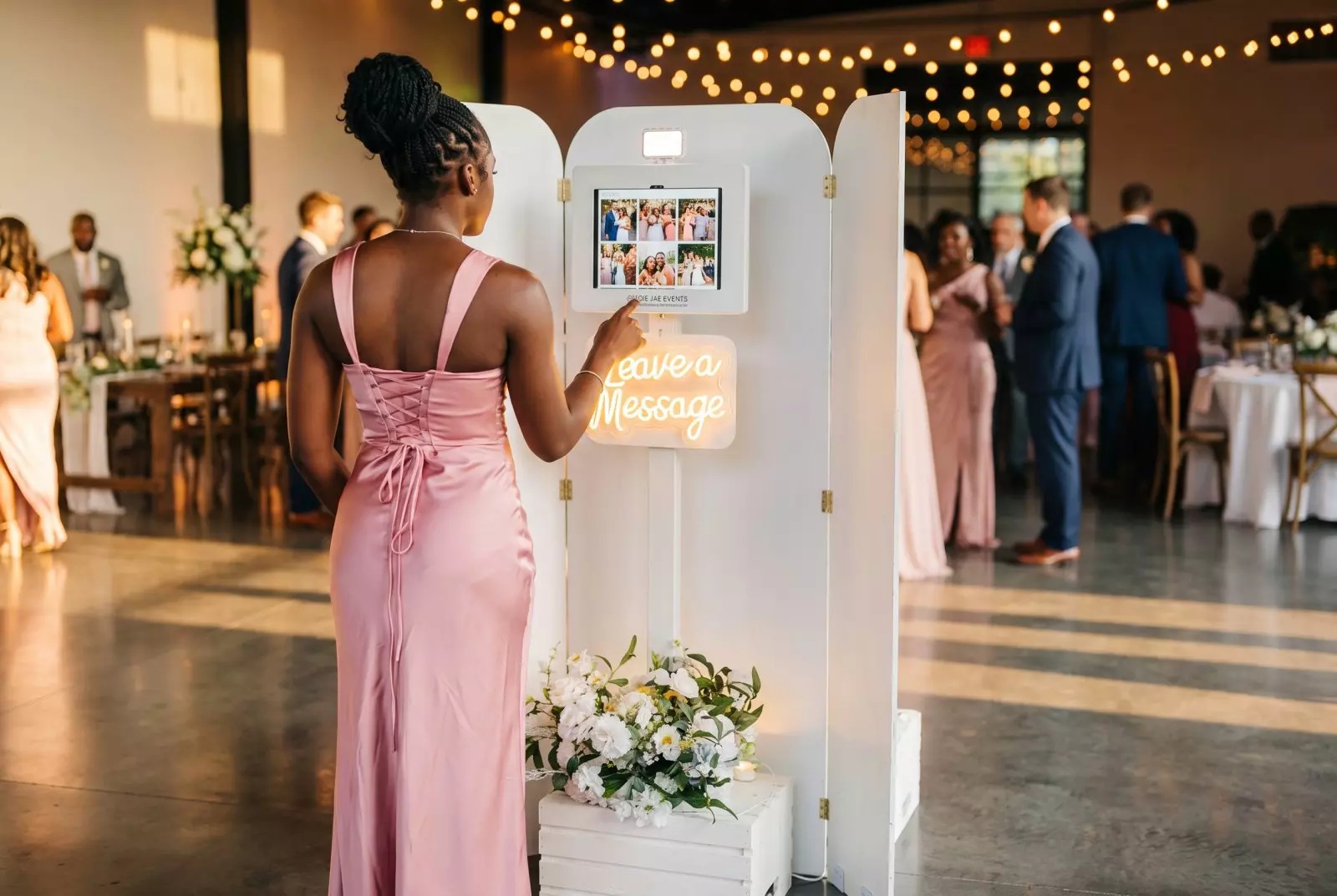 guest standing using a photobooth at a Florida event with other event attendees off in the distance.